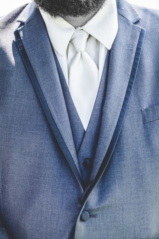 Белый галстук, белая рубашка, синий костюм с жилеткой.
